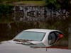 A car sits submerged on a flooded street under a railroad bridge, Thursday, Feb. 1, 2024 in Long Beach, Calif. 