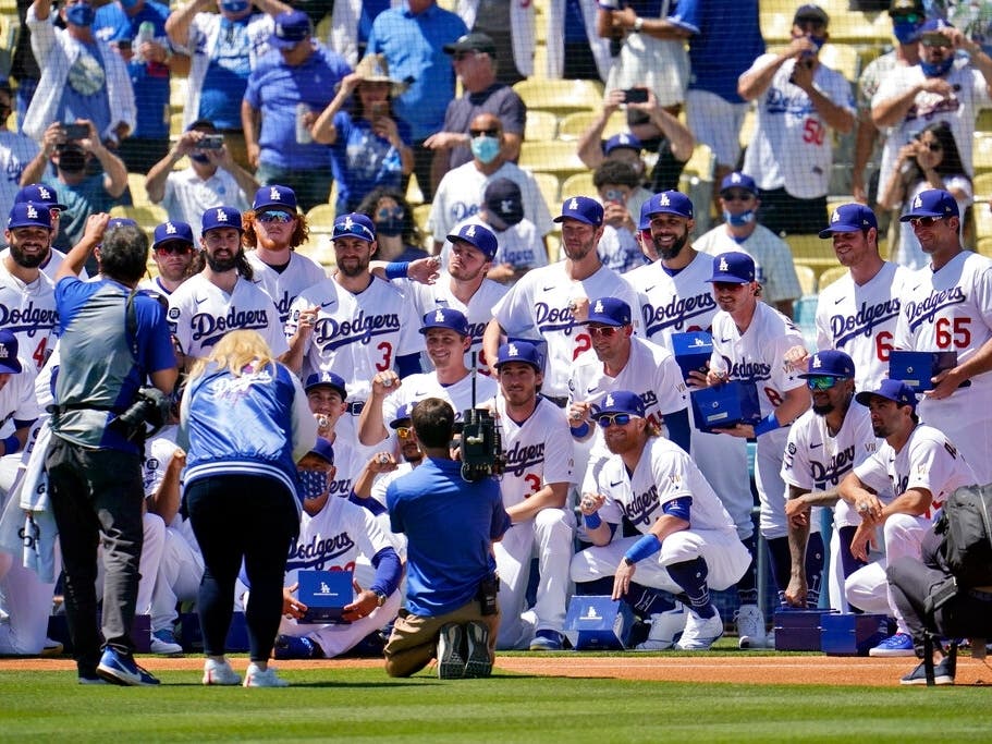 Members of the Los Angeles Dodgers pose for photos with their 2020 World Series Championship rings before a baseball game against the Washington Nationals Friday, April 9, 2021, in Los Angeles. 