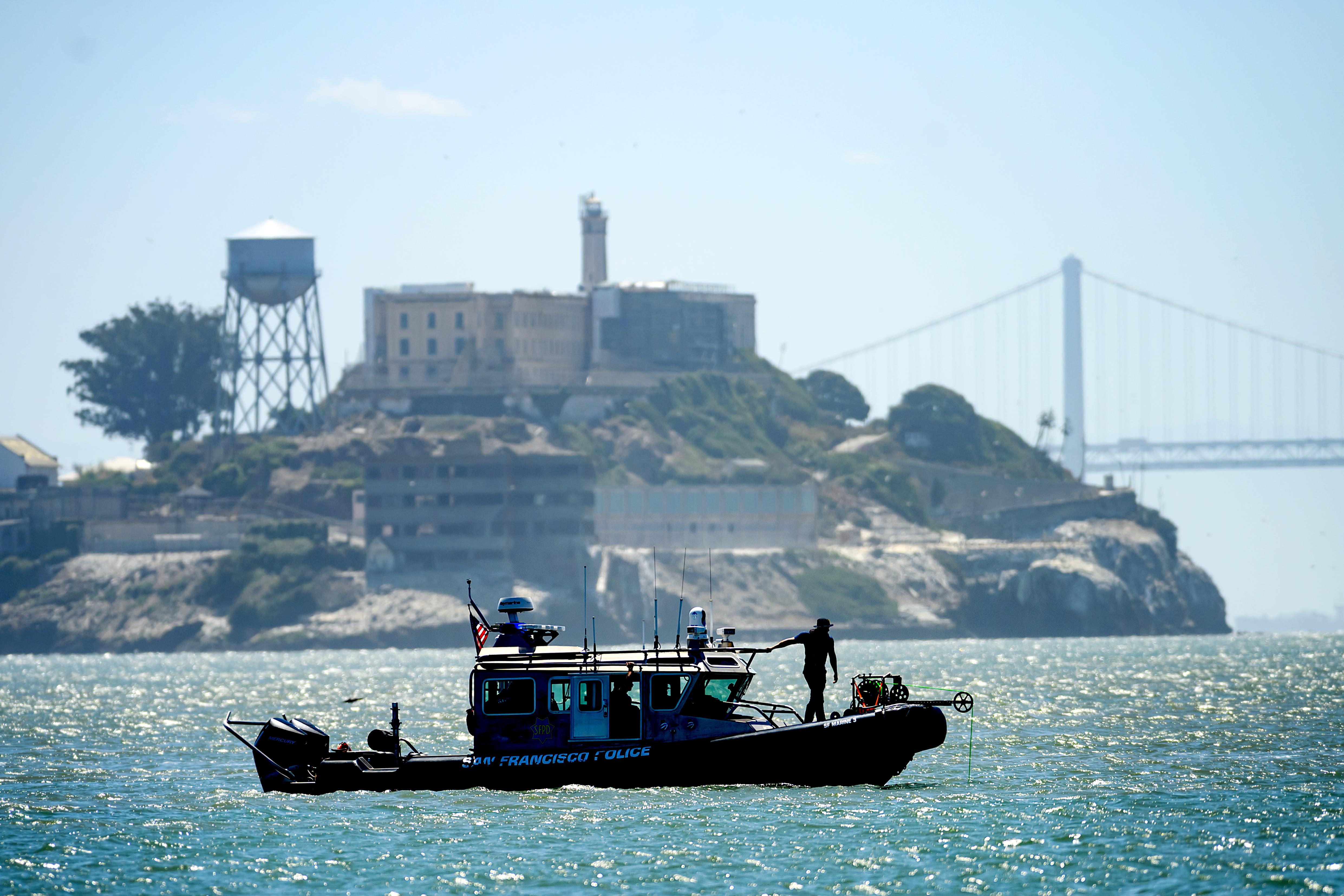 A police boat passes Alcatraz Island as search and rescue operations continue for victims of a Tuesday boat sinking on Wednesday, July 15, 2026, in San Francisco. (AP Photo/Noah Berger)