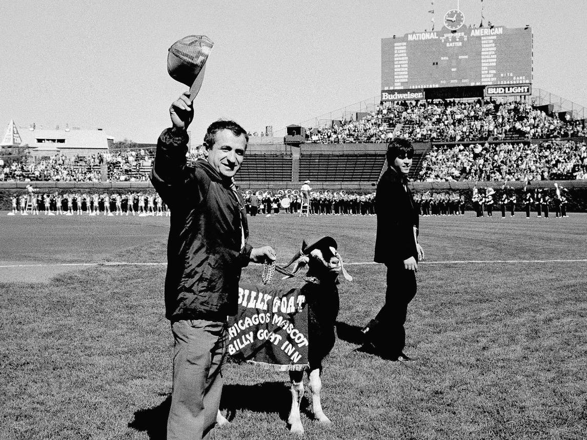 In this Oct. 2, 1984 file photo, Sam Sianis, owner of the Billy Goat Tavern in Chicago, acknowledges the crowd along with his goat prior to a National League baseball playoff game between the San Diego Padres and the Cubs in Chicago.