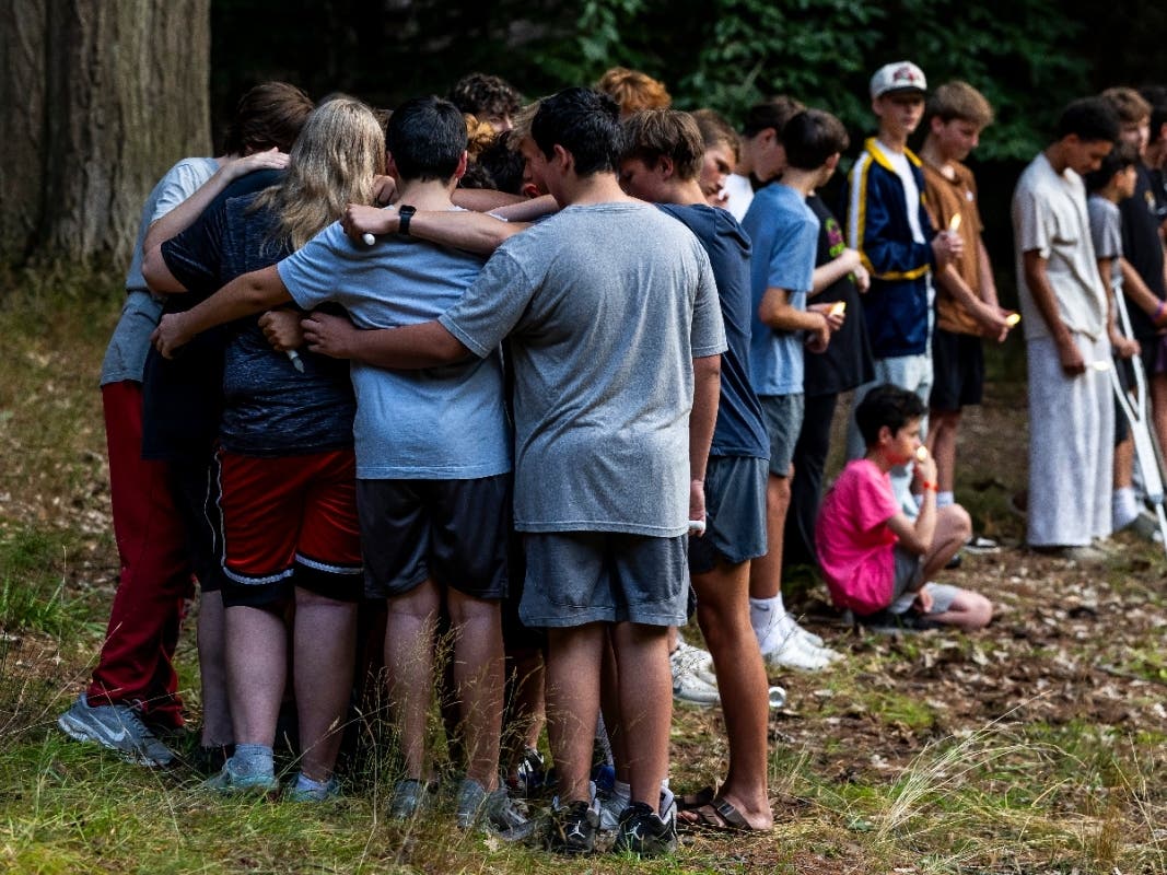 Community members gather during a student-organized vigil at Duncan Woods in Grand Haven, Mich. on Sunday, July 26, 2026, to grieve and honor eight members of a local family who died in a tragedy that has stunned the lakeshore community.
