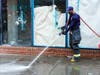 A Philadelphia fireman washes blood off the sidewalk Sunday, June 5, 2022, at the scene of a fatal overnight shooting on South Street in Philadelphia.