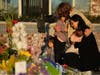 A family gathers at a memorial outside the Star Ballroom Dance Studio on Tuesday, Jan. 24, 2023, in Monterey Park, Calif.