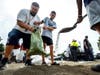 From left; David Rivera makes sandbags with his sons, Zack, 10, center, and Vincent, 18, at Wildwood Park in San Bernardino, Ca., on Saturday, Aug. 19, 2023, as residents gear up for the arrival of Tropical Storm Hilary.