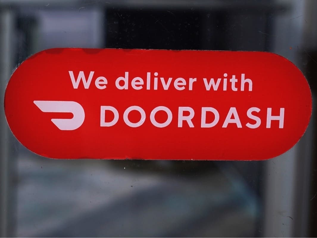 A DoorDash sign is posted on the door of a Dunkin' Donuts franchise Feb. 27, 2023, in Methuen, Mass.