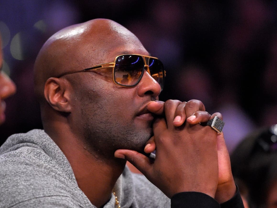 Former Los Angeles Lakers' player Lamar Odom watches during the second half of an NBA basketball game between the Lakers and the Miami Heat in Los Angeles, March 30, 2016.