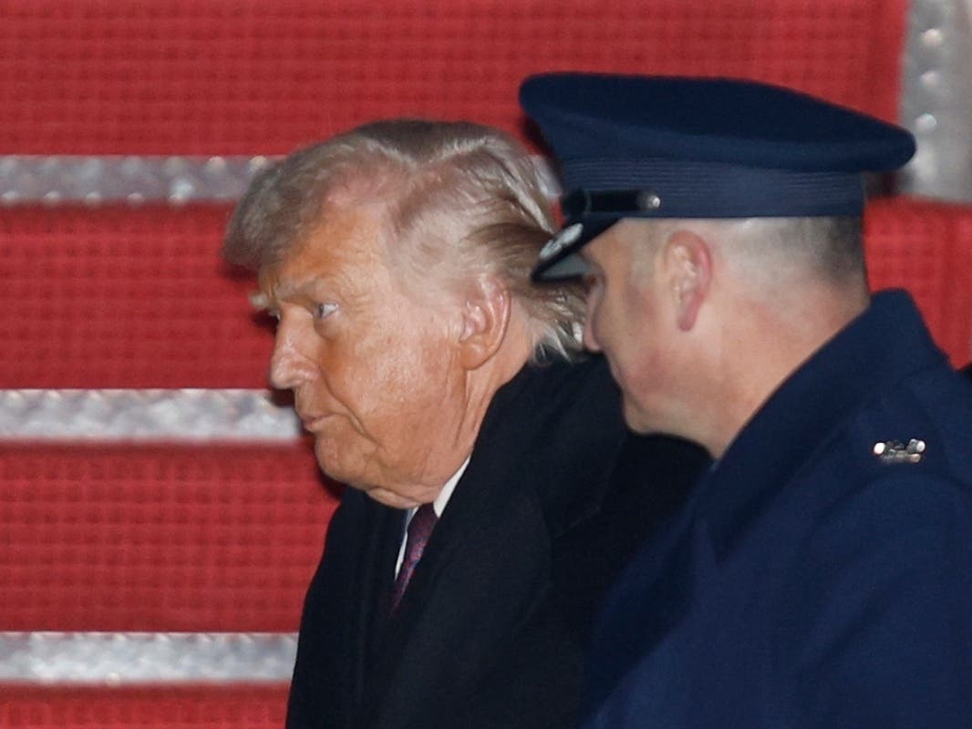 President Donald Trump, left, is greeted by Air Force Col. Christopher M. Robinson, commander of the 89th Airlift Wing, right, after walking down the stairs of Air Force One, upon his arrival at Joint Base Andrews, Md., Thursday, Jan. 22, 2026.