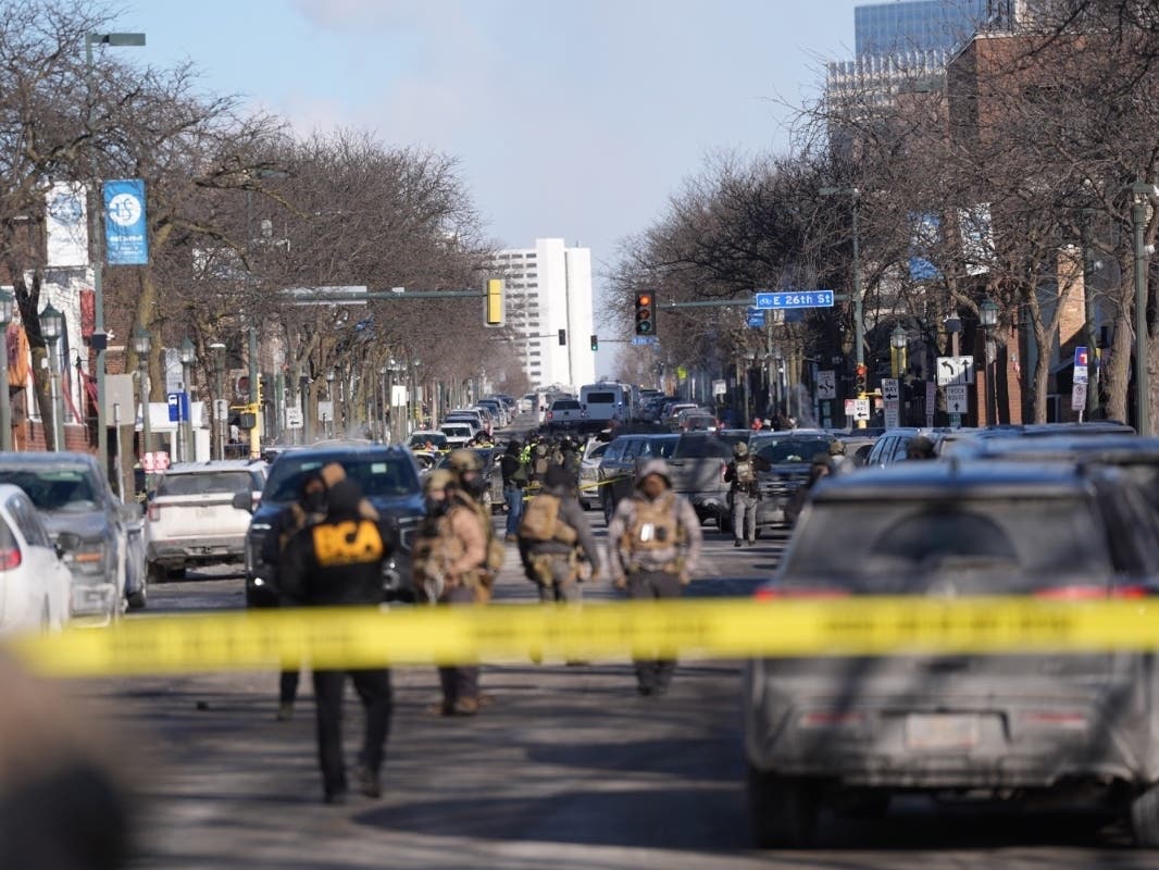 Federal agents stand near the site of a shooting Saturday, Jan. 24, 2026, in Minneapolis.