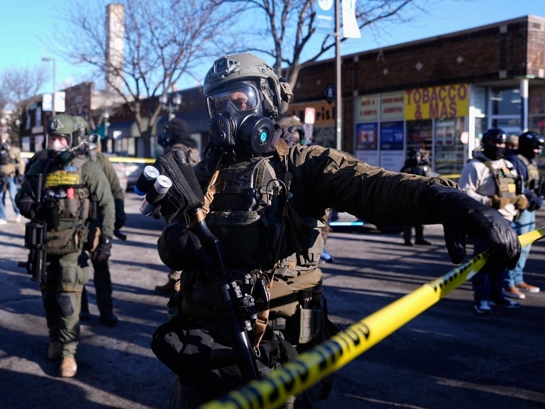 Federal agents stand near the site of a shooting Saturday, Jan. 24, 2026, in Minneapolis.