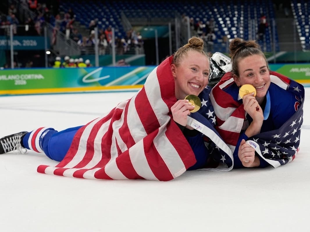 United States' Grace Zumwinkle, left, and Taylor Heise celebrate after victory ceremony for women's ice hockey at the 2026 Winter Olympics, in Milan, Italy, Thursday, Feb. 19, 2026.