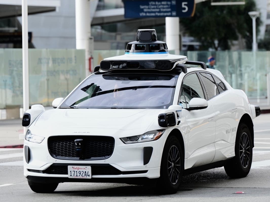 A passenger inside a Waymo vehicle looks out of the window while leaving the San Jose Mineta International Airport, Wednesday, Nov. 12, 2025, in San Jose, Calif.