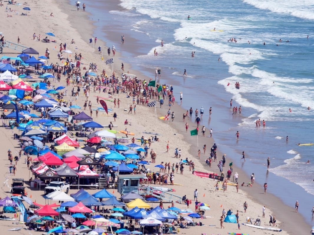 Beach goers watch during the the 46th Annual California Surf Lifesaving Championships on Will Rogers State Beach Friday, July 24, 2026, in the Pacific Palisades section of Los Angeles.