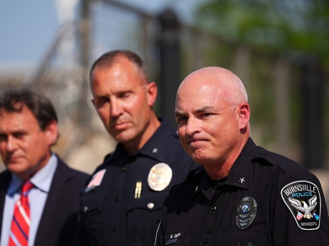 Burnsville Police Chief Matt Smith, right, attends a news conference in Hopkins, Minn., Wednesday, Aug. 12, 2026.