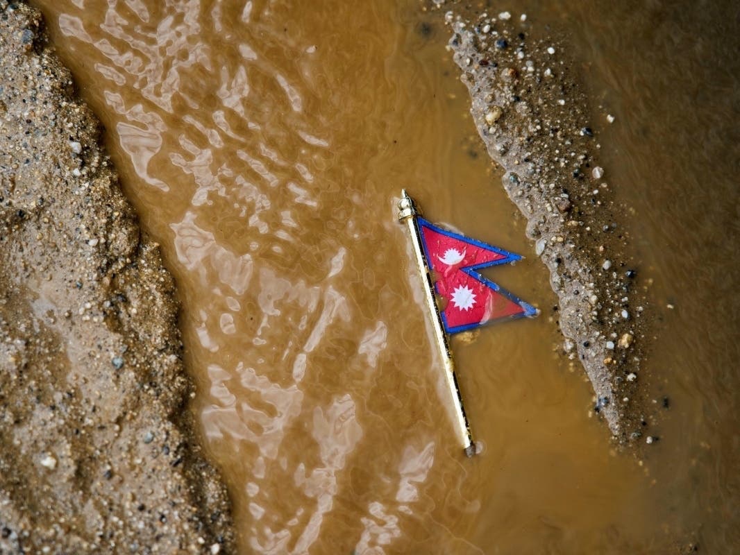 A Nepal flag lies on a muddy track near the banks of the Trishuli river in Dhading District, Nepal, Sunday, Aug. 30, 2026.