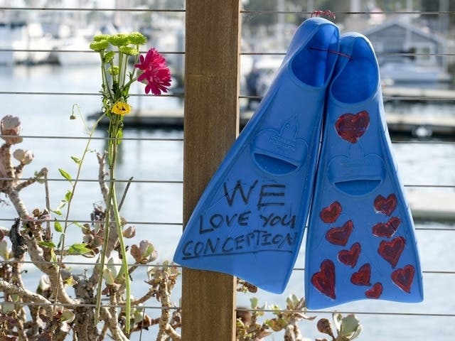 A pair of fins and flowers are placed on the outside of the Sea Landing at Santa Barbara Harbor in Santa Barbara, Calif., Monday, Sept. 2, 2019.