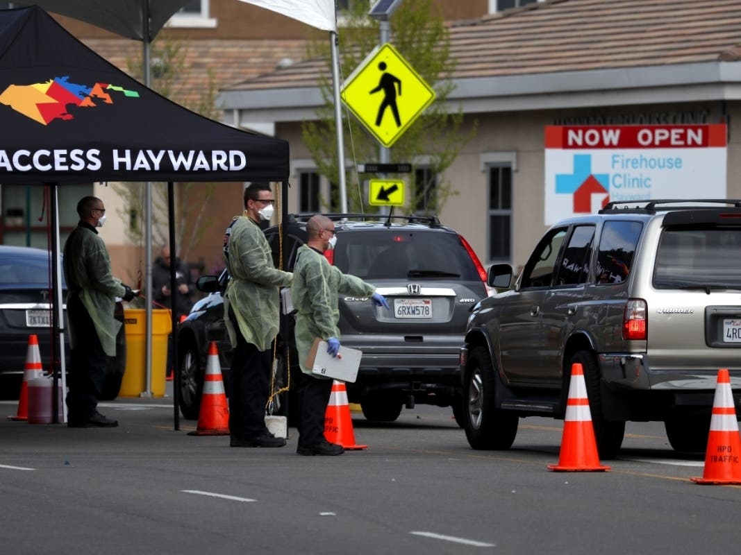 Firefighters screen people that are waiting in line to get a COVID-19 test at a free public testing station on March 24, 2020 in Hayward, California. Hundreds of people are lining up to receive a COVID-19 test offered by the City of Hayward free of charge