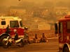 Redwood City firefighters take a break as they mop up hot spots Monday at homes that were destroyed by the Glass Incident Fire in Santa Rosa.