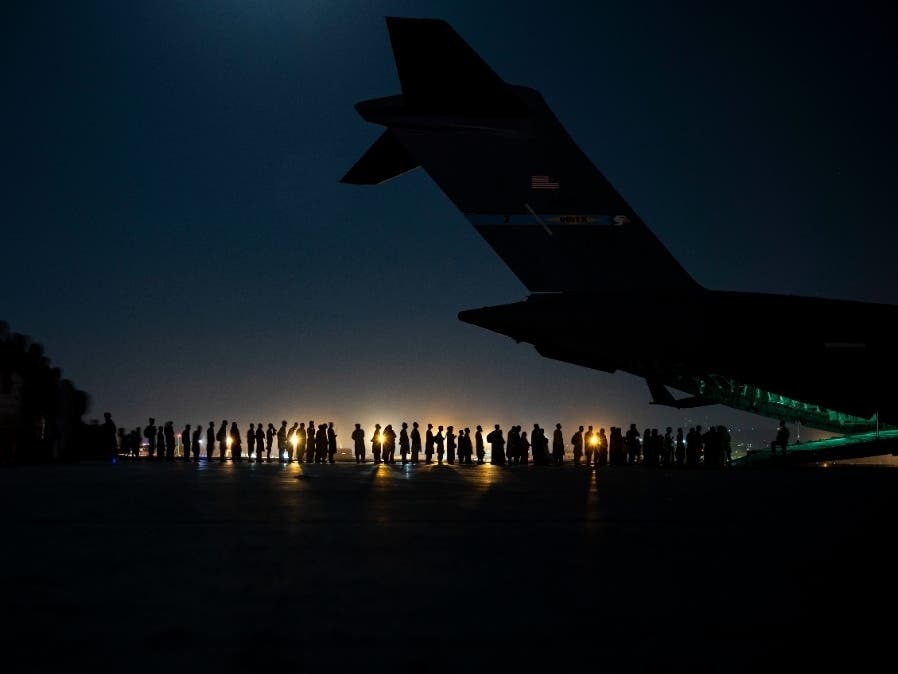 Afghan refugees line up to board a C-17 Globemaster III aircraft at Hamid Karzai International Airport in Kabul, Afghanistan, on Saturday. Joint Base McGuire-Dix-Lakehurst is slated to provide temporary housing and assistance to refugees in the U.S.