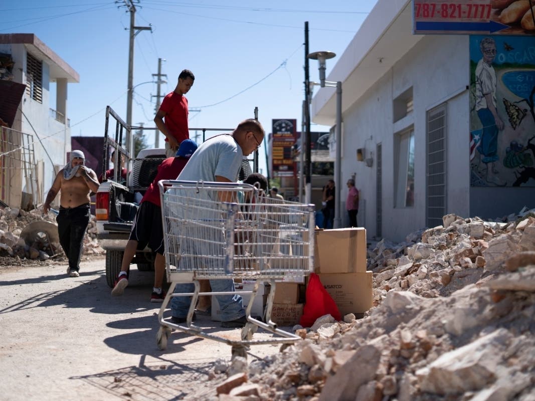 People inspect damage and help to take merchandise out of a local store after a 6.4 earthquake hit just south of the island on January 7, 2020 in Guánica, Puerto Rico.