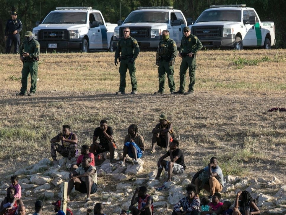 U.S. Border Patrol agents watch over immigrants near a migrant camp in Del Rio, Texas on September 22, 2021.