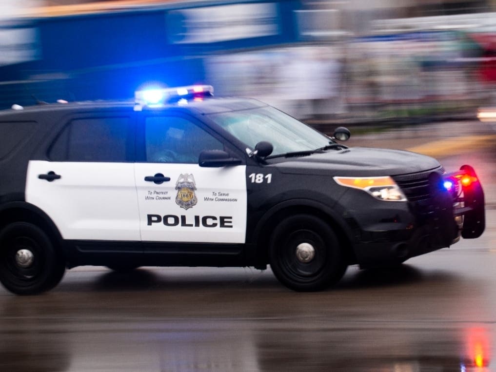 A police car drives by as protesters clash with police while demonstrating against the death of George Floyd outside the 3rd Precinct Police Precinct on May 26, 2020, in Minneapolis, Minnesota.