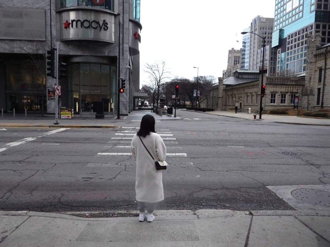 A woman waits for the light to change before crossing a nearly deserted Michigan Avenue on March 20 in Chicago. 