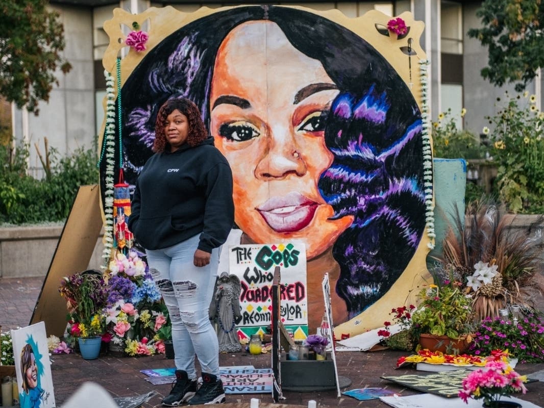 Tamika Palmer, mother of Breonna Taylor, poses for a portrait in front of a mural of her daughter at Jefferson Square Park on Monday in Louisville, Ky. Demonstrators have occupied the park for 120 days.