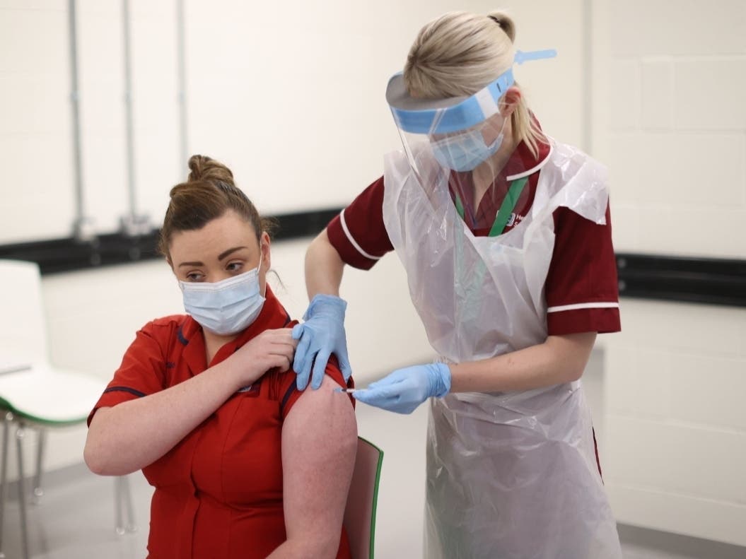 Sister Joanna Sloan becomes the first person in Northern Ireland to receive the first of two Pfizer/BioNTech COVID-19 vaccine jabs Tuesday at the Royal Victoria Hospital in Belfast.