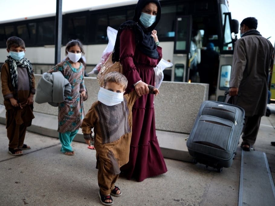 Refugees board buses that will take them to a processing center at Dulles International Airport after being evacuated from Kabul following the Taliban takeover of Afghanistan on Aug. 27, in Dulles, Virginia.
