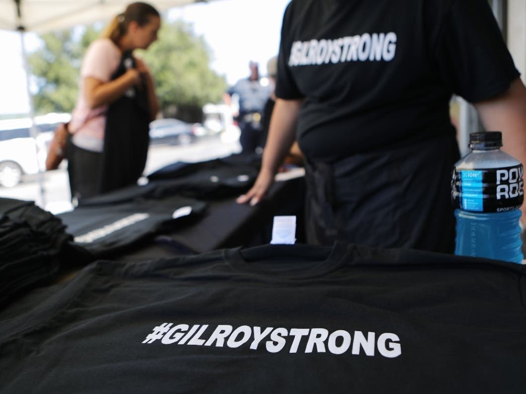 A woman (L) prepares to purchase '#GILROYSTRONG' t-shirts at Cal Silk two days after a mass shooting at the Gilroy Garlic Festival on July 30, 2019 in Gilroy, California.