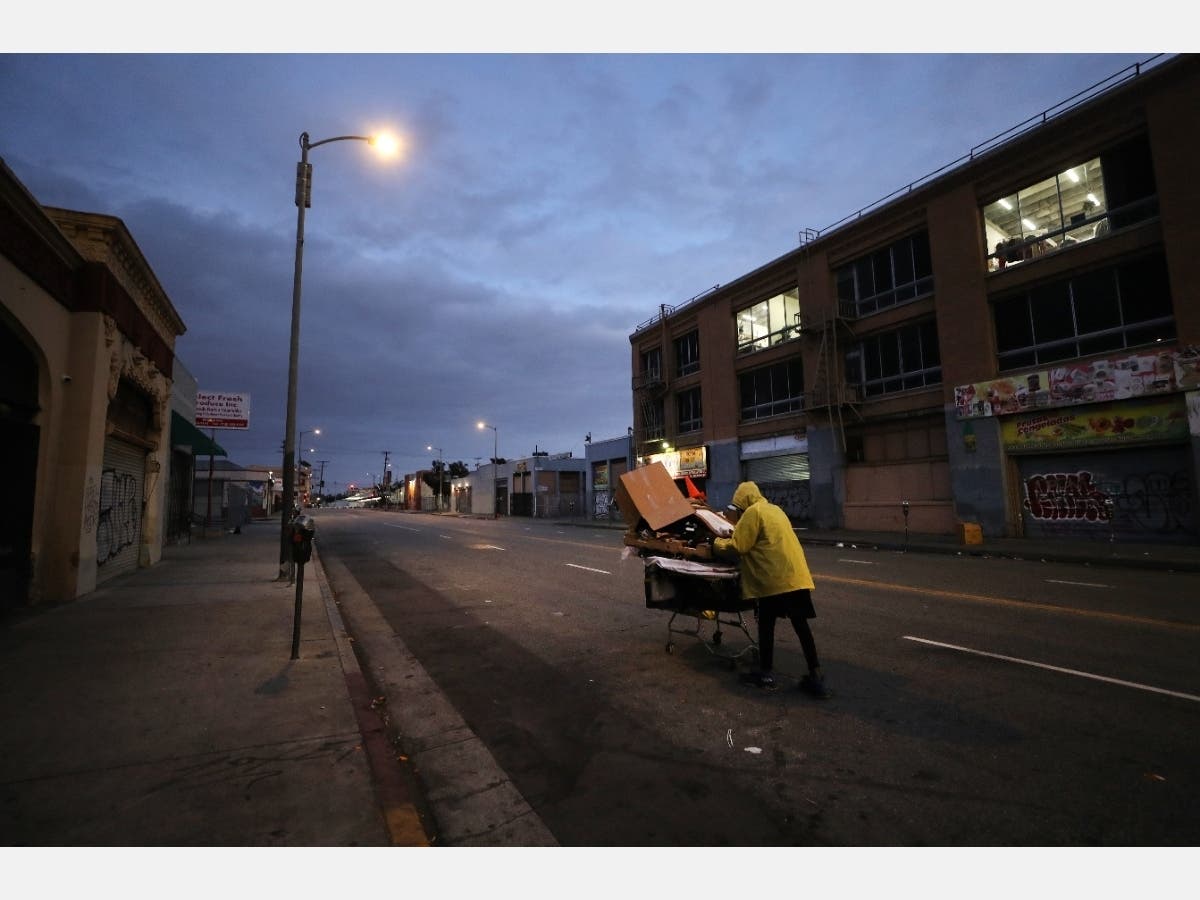 Mal, who is originally from Texas and currently homeless, pushes a cart with his belongings on a downtown street amidst the coronavirus pandemic on April 18, 2020 in Los Angeles, California. 