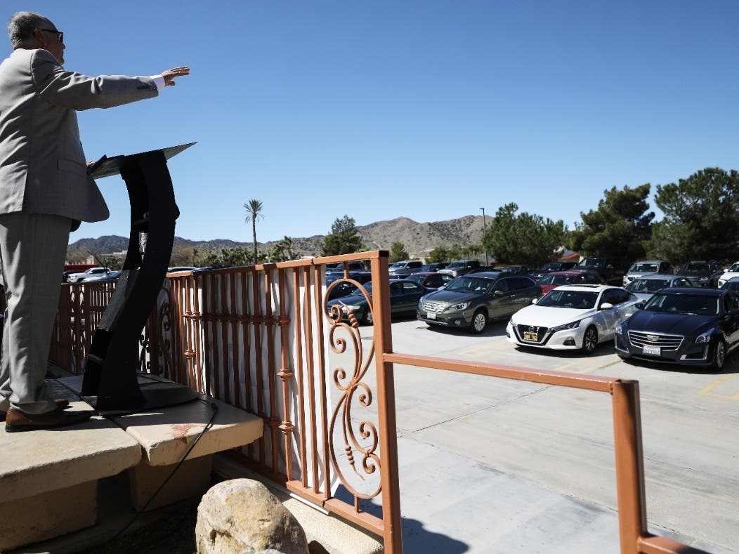 astor Jerel Hagerman conducts a drive-in ‘car church’ Easter service in the parking lot of Joshua Springs Calvary Chapel amidst the coronavirus pandemic on April 12, 2020 in Yucca Valley, California.