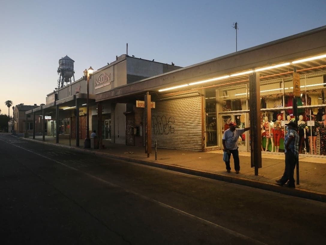 Men wait at dawn in order to be the first in line to enter a bookkeeping shop to fill out unemployment forms near the U.S.-Mexico border in Imperial County, which has been hard-hit by the COVID-19 pandemic, on July 24, 2020 in Calexico, California.