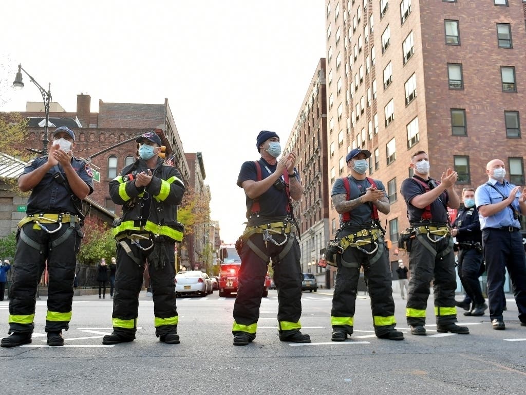 Firefighters from FDNY Engine 47 salute health care workers during a "Clap Because We Care" outside of Mount Sinai Morningside hospital in New York City.