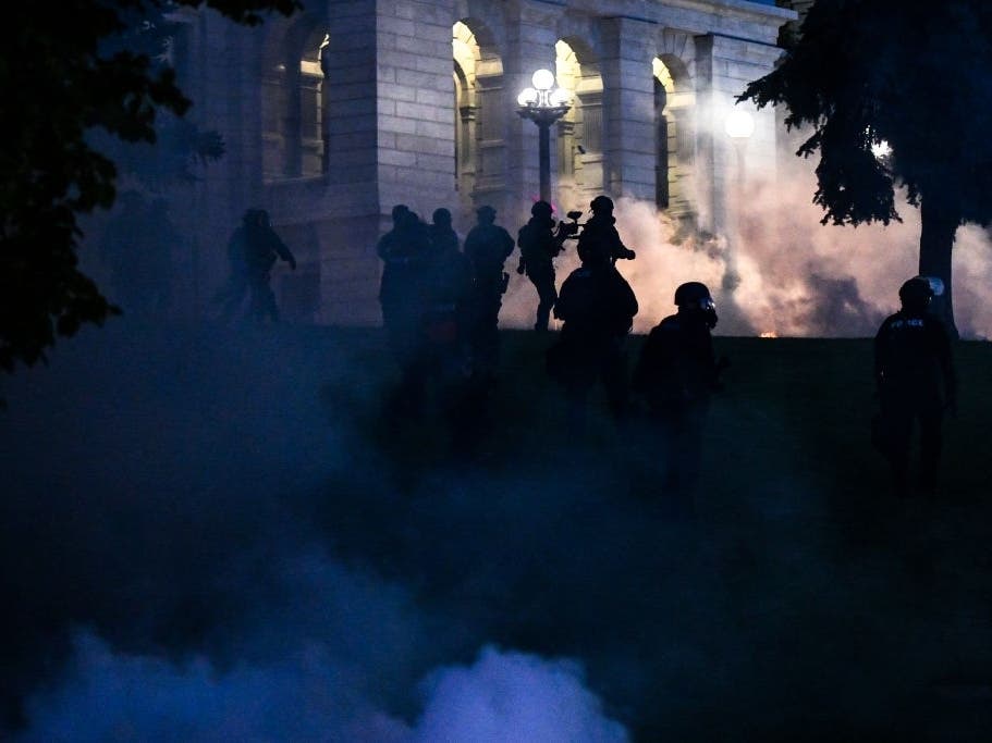 Police officers fire tear gas at protesters in Denver after the death of George Floyd, who died in police custody in Minneapolis. 