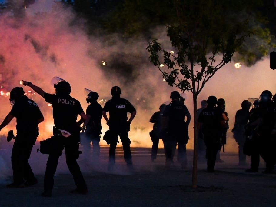 Police officers fire tear gas at protesters in Denver after the death of George Floyd, who died in police custody in Minneapolis.