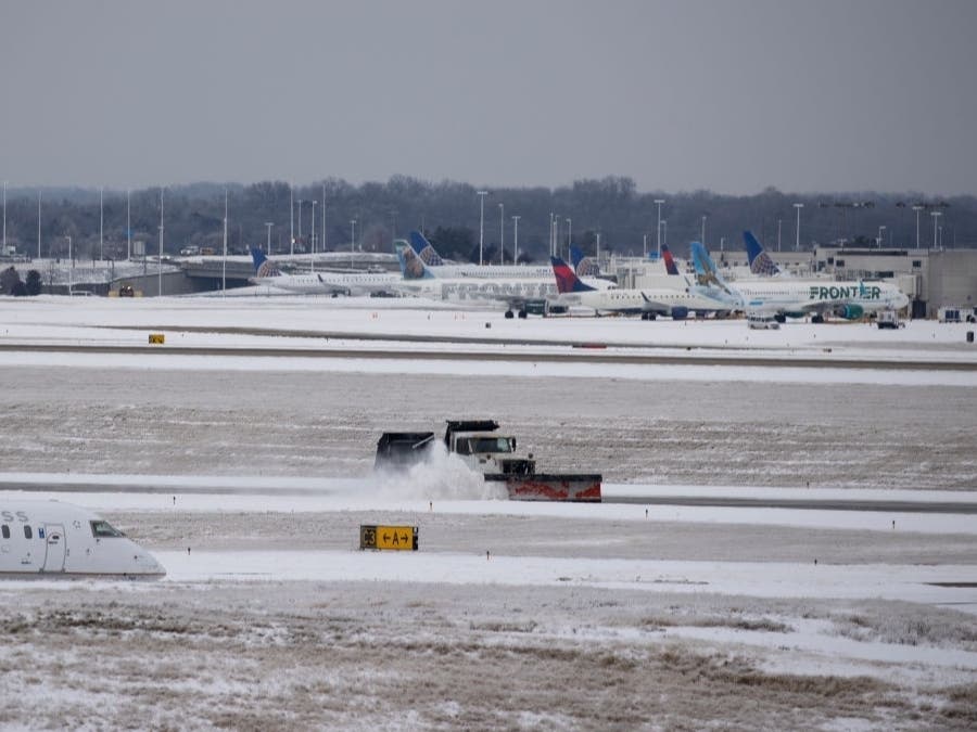 Vehicles remove snow from Nashville International Airport on Tuesday. A storm hit Tennessee and halted COVID-19 vaccine shipments to Colorado, officials said.