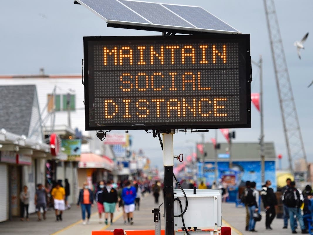 A sign placed on the boardwalk states "MAINTAIN SOCIAL DISTANCE" on May 24, 2020 in Wildwood, New Jersey. Governor Phil Murphy designated the state beaches open with restrictions during the Memorial Day weekend due to the coronavirus pandemic.