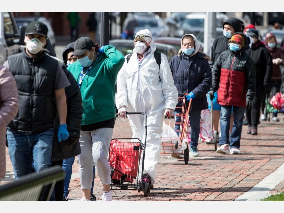 Residents line up to recieve food distributed by the National Guard at Chelsea City Hall on April 17, 2020, in Chelsea, Massachusetts. Chelsea has the highest concentration of COVID-19 infections as well as essential workers in the state.