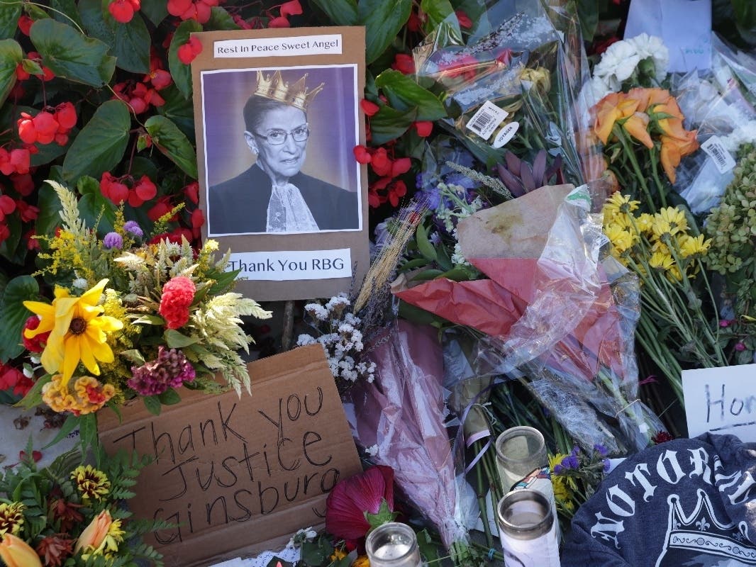 WASHINGTON, DC - SEPTEMBER 21: Signs and flowers are left at a makeshift memorial in front of the U.S. Supreme Court for the late Justice Ruth Bader Ginsburg September 21, 2020 in Washington, DC.