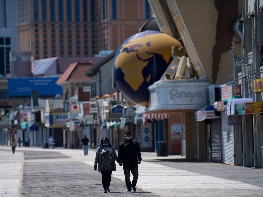 A couple walks on the Atlantic City boardwalk Tuesday. Atlantic County officials submitted a proposal for reopening parts of their economy.