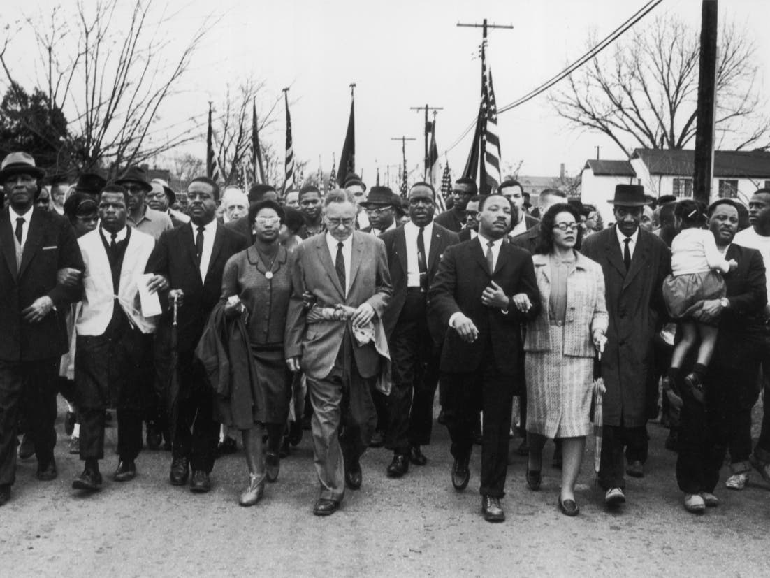 ​Martin Luther King Jr. and his wife, Coretta Scott King, lead a Black voting rights march from Selma to Montgomery, Alabama, in 1965. Also pictured (front row) are John Lewis, the Rev. Ralph Abernathy, Ruth Harris Bunche, Ralph Bunche and Hosea Williams.