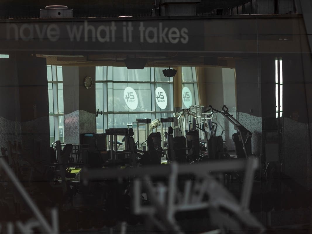 Idled exercise equipment stands in a darkened 24 Hour Fitness center as Los Angeles County allows more businesses and facilities to reopen today, despite rising COVID-19 infections and deaths on June 12, 2020 in Los Angeles.