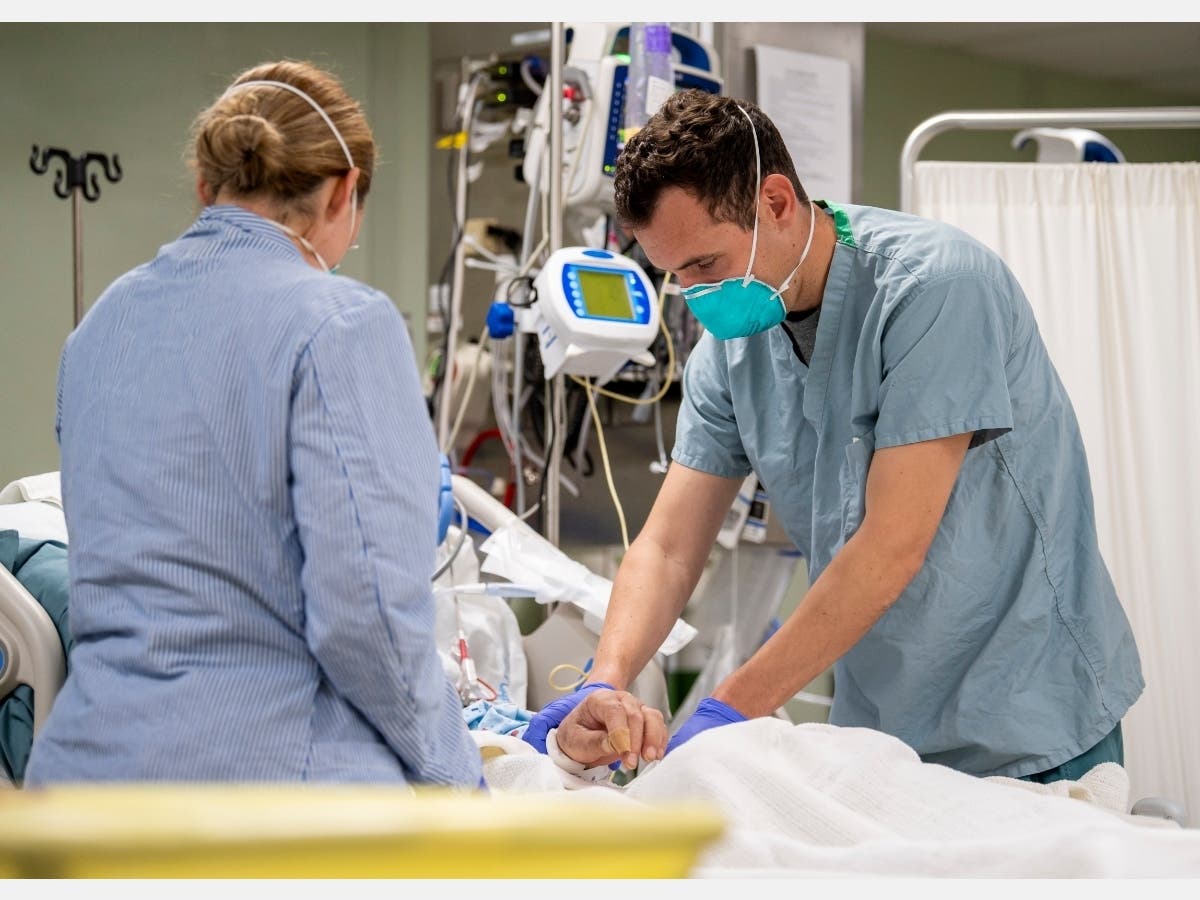  In this handout released by the U.S. Navy, Lt. Wade Miller, from Orlando, Fla., treats a patient aboard the hospital ship USNS Mercy in Los Angeles (T-AH 19), April 4, 2020. 