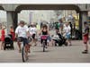 People ride bikes and walk on a path along the beach on April 26, 2020 in Huntington Beach, California. Southern California is expecting summer-like weather this weekend as social distancing and beach closures in neighboring counties continue.