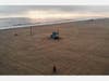 An aerial view of people embracing before sunset on a nearly empty Venice Beach, which remains closed along with all other Los Angeles County beaches under stay-at-home orders, amid the coronavirus pandemic on April 26, 2020 in Venice, California.