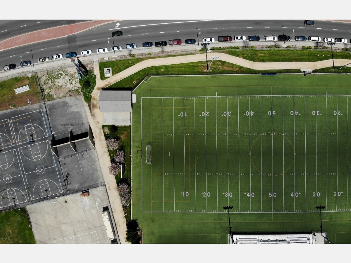 An aerial view of cars lined up to receive food distributed by the Los Angeles Regional Food Bank and the city, as basketball courts and a football field stand empty at the shuttered Ruben Salazar High School, amidst the coronavirus pandemic on April 28.