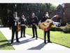 A mariachi band, some wearing face masks, wait to perform near Los Angeles Mayor Eric Garcetti’s home during a May Day protest calling for a rent moratorium to help tenants during the coronavirus pandemic on May 1, 2020 in Los Angeles, California.
