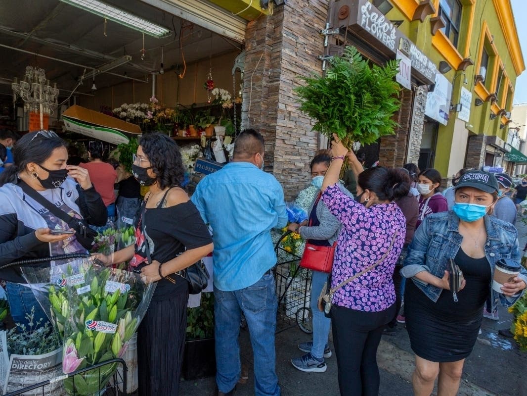 People mingle in close proximity to one another as businesses in the flower district in Skid Row reopen in time for Mothers Day on May 8, 2020 in Los Angeles. Local stay-at-home restrictions are being relaxed to allow the reopening of some businesses.