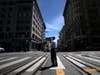 A U.S. Postal Service letter carrier stands in the middle of Powell Street on May 15, 2020 in San Francisco, California.